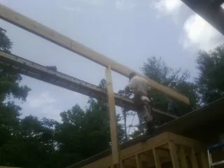 Carpenter setting a ridge beam over a new addition frame — Ice Dam Removal by Roofing Brothers in Oneida